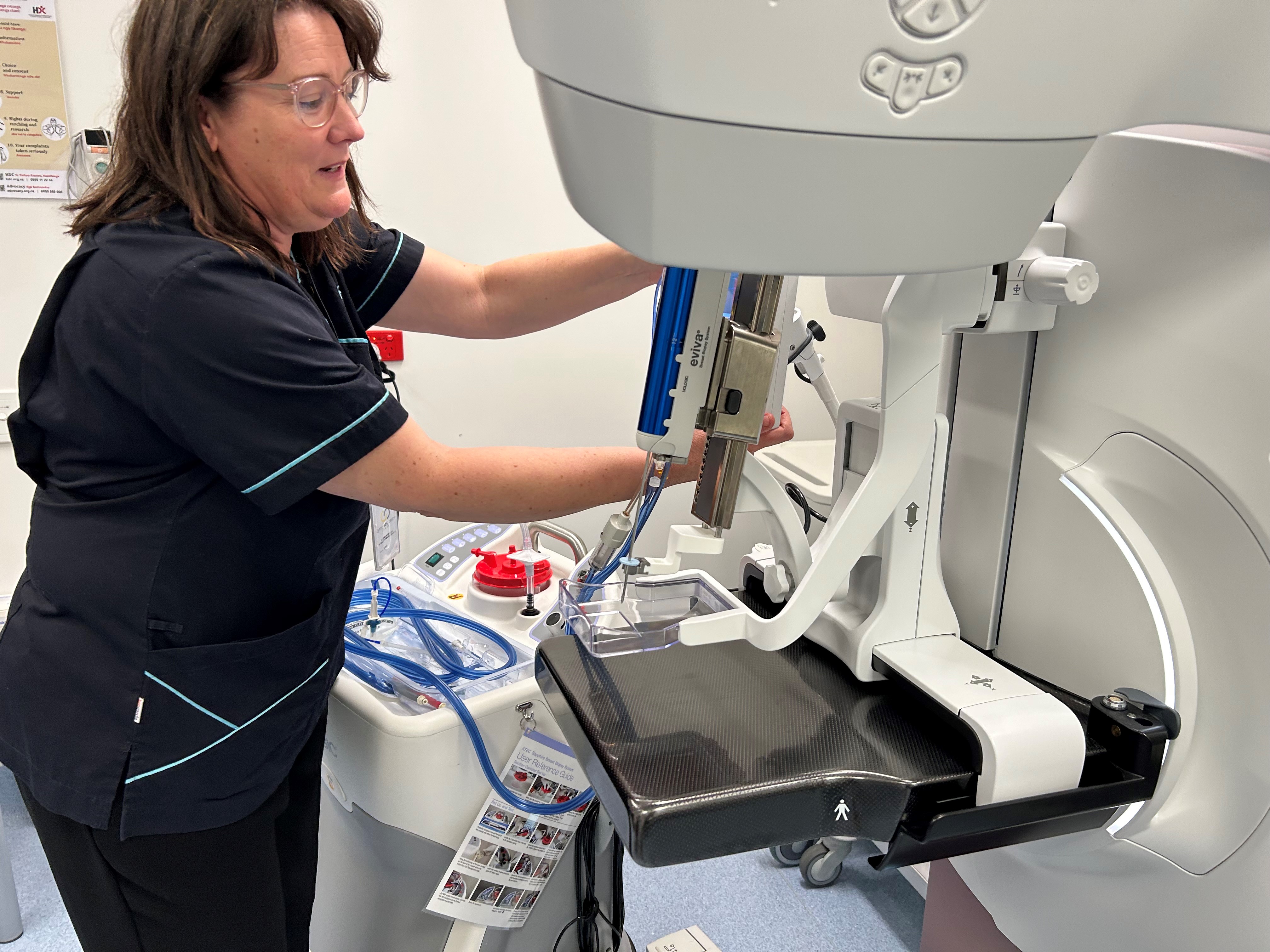 Radiology technician adjust a new 3D mammogram machine.