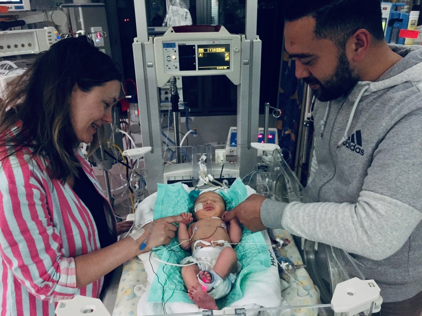 Jen and Jesse watch over baby Elle in the NICU