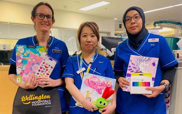 ICU nurses hold kids items from comfort packs