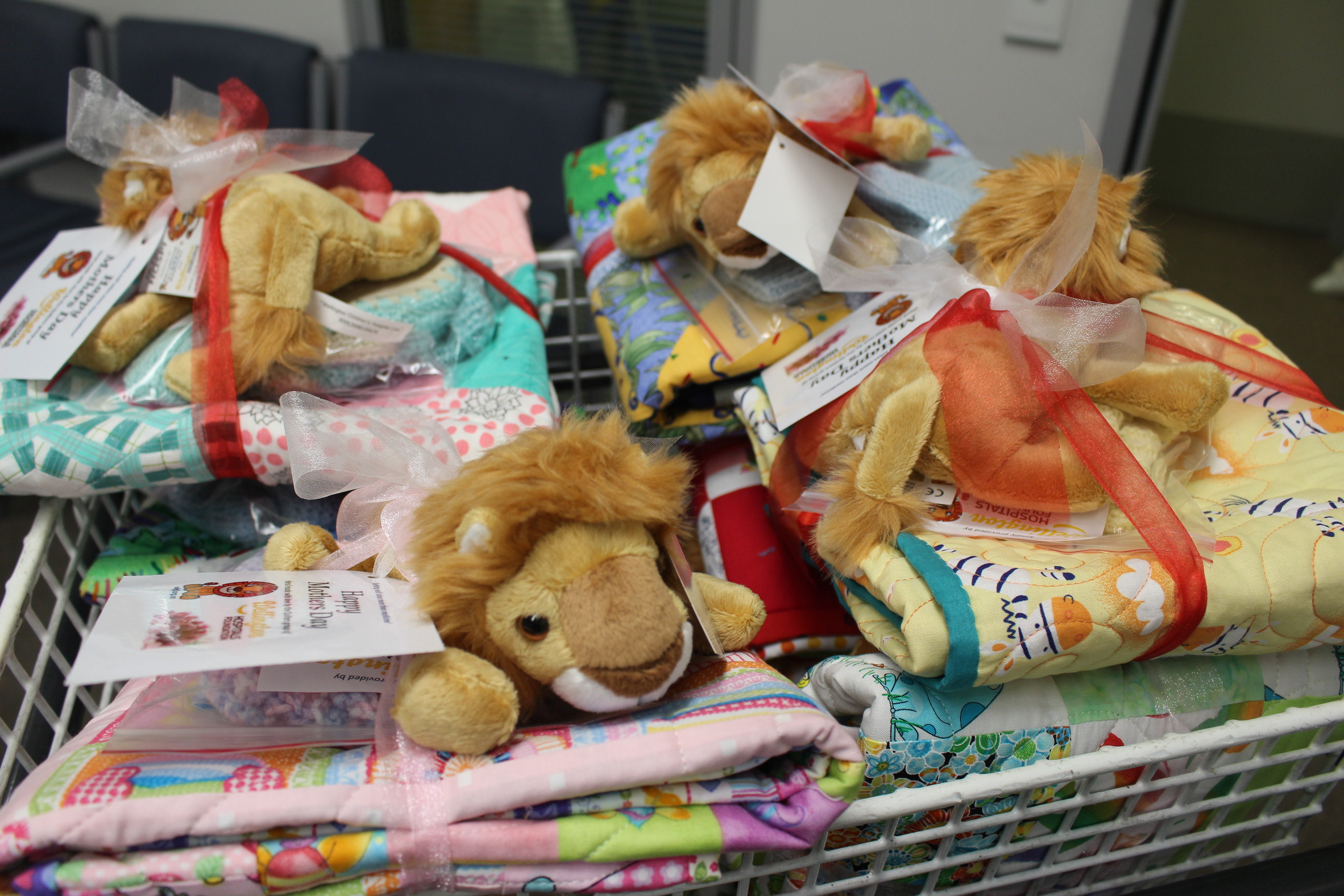 Mother’s Day gift packs for new mums. The packs include a handmade quilt, beanie and booties set, and a soft-toy Hospi. 